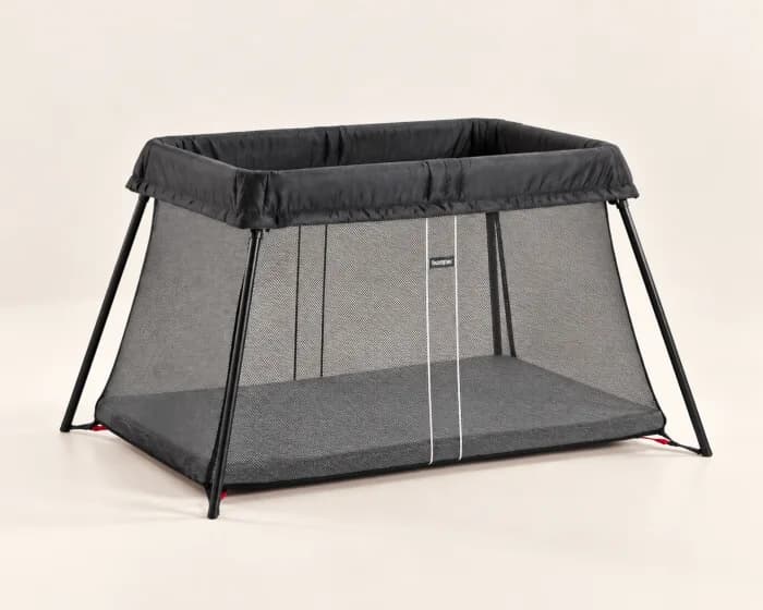 A folding travel cot on a light background.
